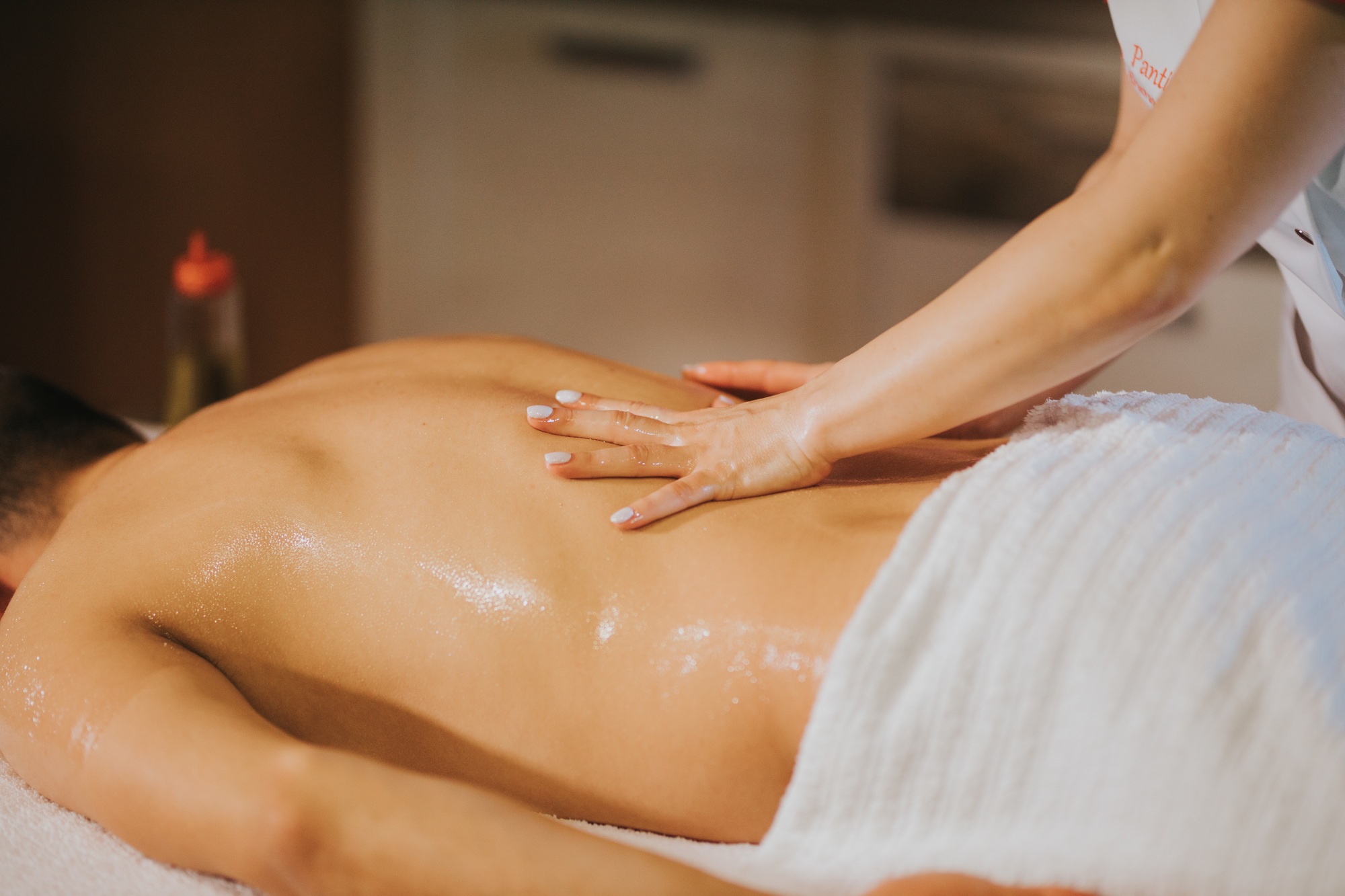 Closeup of a masseuse massaging a man in a spa